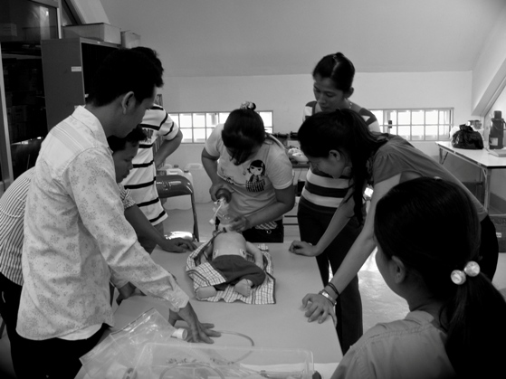 Local doctors practising on a dummy during a skill transfer session